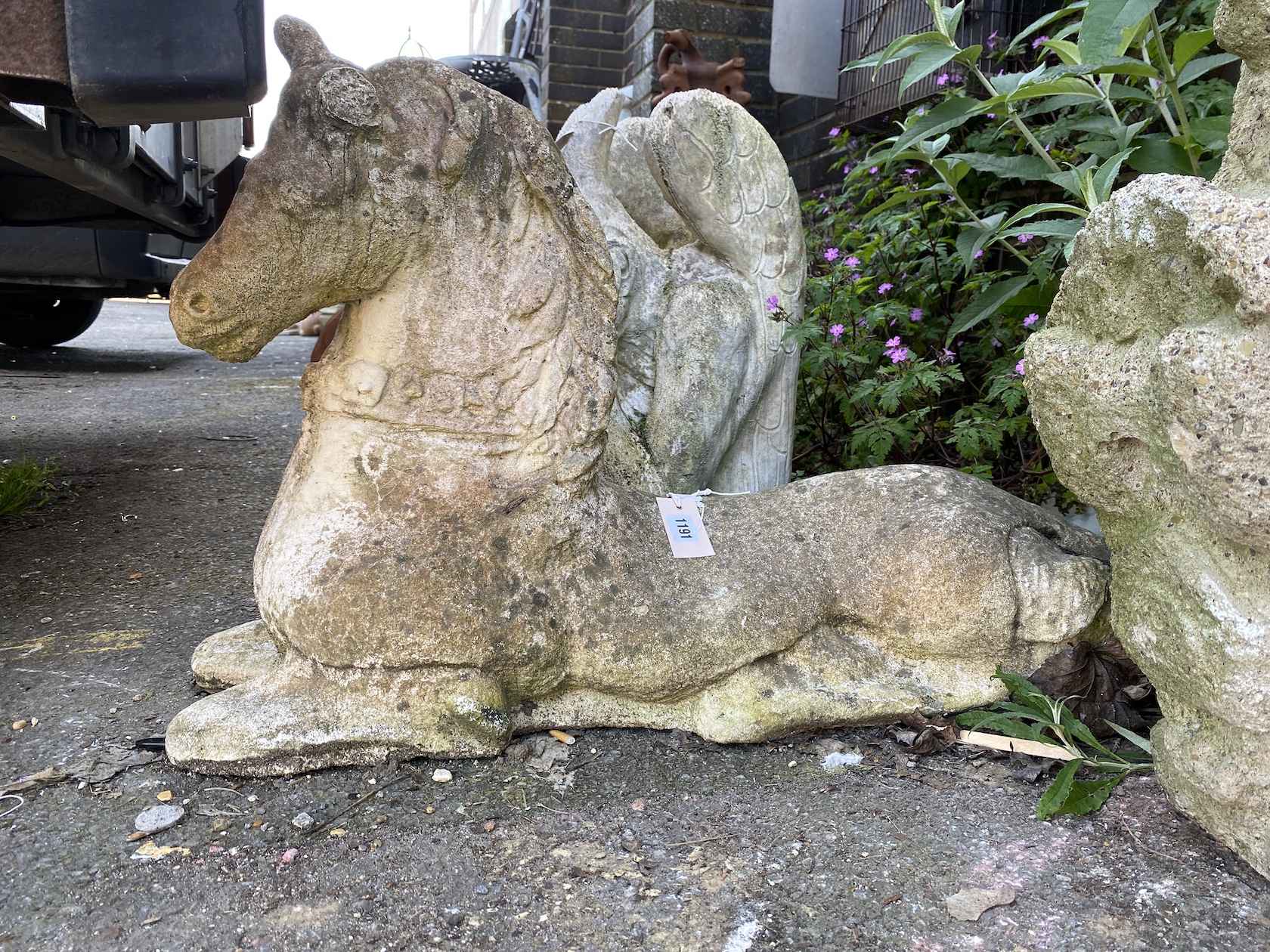 A reconstituted stone recumbent horse, height 55cm *Please note the sale commences at 9am.